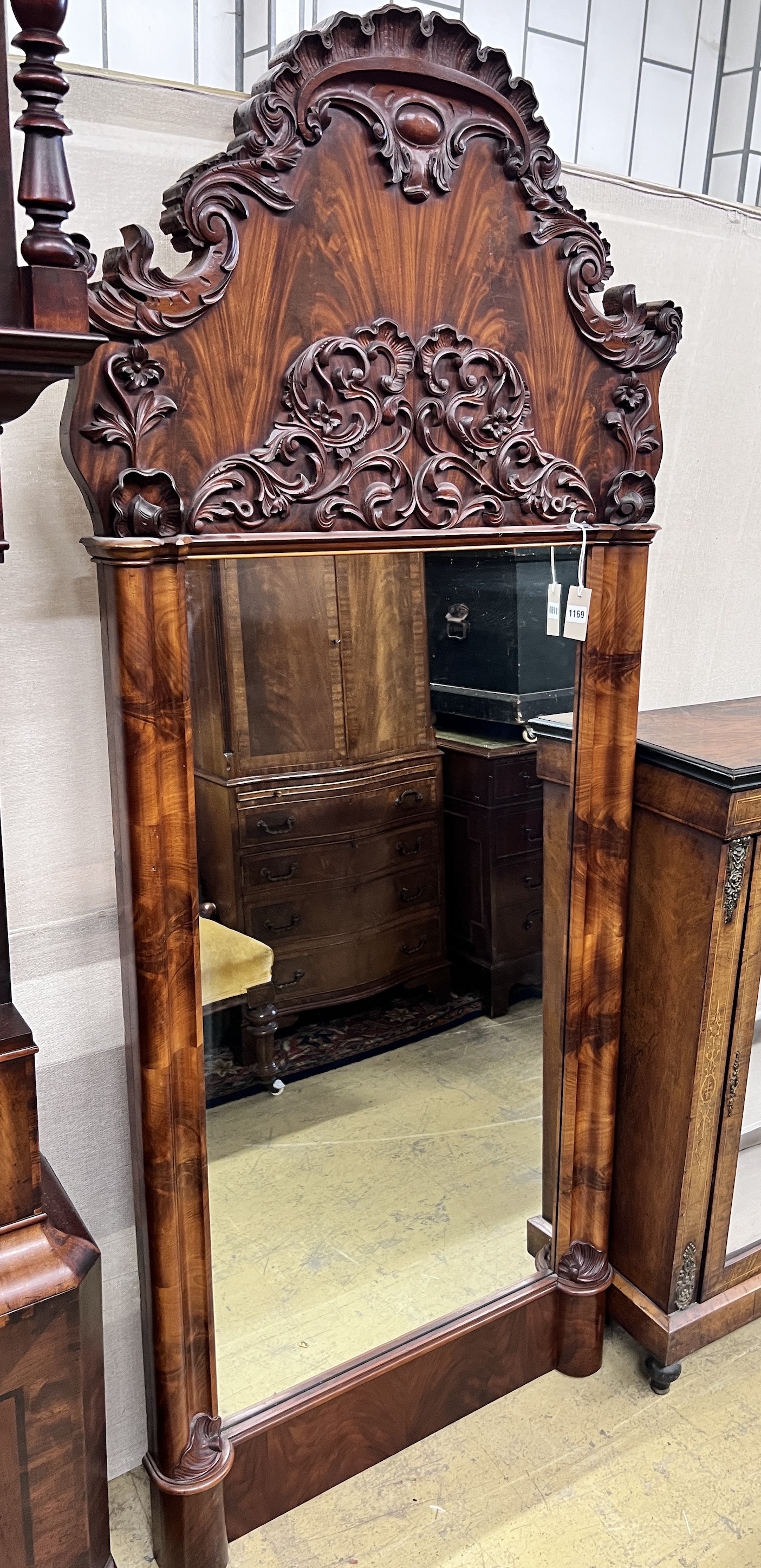 A 19th century French flame mahogany pier glass, with scroll carved pediment, width 88cm, height 193cm